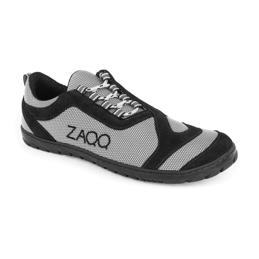 Der ZAQQ QI Black ist ein veganer Sportschuh mit einem schwarz-grauen Mesh-Design mit dezenten schwarzen Akzenten und einer strapazierfähigen schwarzen Gummisohle. Seine Optik als Outdoor-Laufschuh wird durch schwarze und weiße Schnürsenkel unterstrichen, die zu seinem allgemeinen Komfort beitragen.