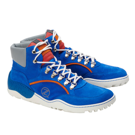 Die TERRAQ Azure Waterproof Sneaker von ZAQQ sind leuchtend blaue High-Tops mit grauen Knöchelbündchen und rot-orangen Akzenten. Sie sind als Outdoorschuhe konzipiert und verfügen über weiße Schnürsenkel mit silbernen Ösen sowie eine markante dicke weiße Sohle, die für optimale Traktion sorgt.