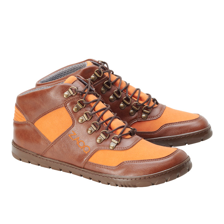 Ein Paar orangefarbene High-Top-Sneaker mit braunen Akzenten, braunen Schnürsenkeln und Metallösen. Das ZAQQ HIQE Mid Vegan Orange Waterproof-Branding ist an der Seite zu sehen. Diese wasserdichten Schuhe verfügen über eine strapazierfähige ZAQQ Outdoor-Sohle und sind damit perfekt für Outdoor-Barfuß-Enthusiasten, die vegane Optionen bevorzugen. Sie sind auf einem weißen Hintergrund abgesetzt.