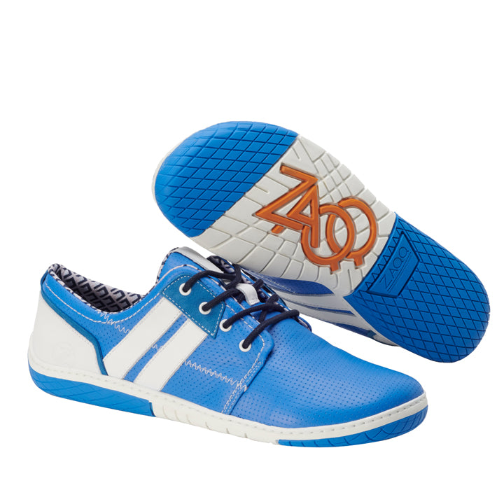 Ein Paar QAPETOWN Blue-Sneaker von ZAQQ mit weißen und grauen Akzenten und gestreiften Details. Ein Schuh steht aufrecht, während der andere auf der Seite liegt und eine Sohle mit einem orangefarbenen ZOO-Logo zeigt. Diese Sneaker sind für ihre Atmungsaktivität bekannt und bieten Komfort und Stil bei jedem Schritt.