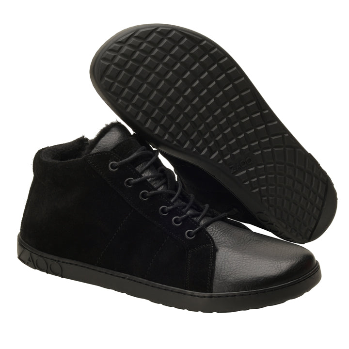 Ein Paar knöchelhohe Schuhe ZAQQ QORE Mid Winter Black mit strukturierten Gummisohlen. Diese Barfußschuhe zeichnen sich durch ein Schnürdesign aus, das Einsätze aus Wildleder und Leder kombiniert. Ein Schuh steht aufrecht, während der andere die Sohle betont.