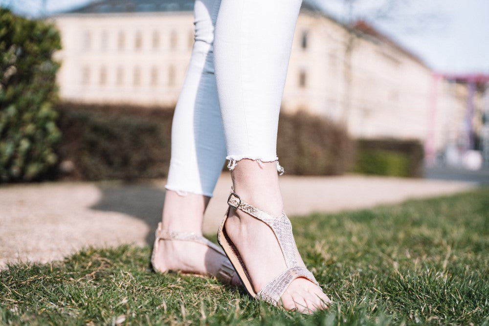 Bei diesen CLIQ Gold-Sandalen von ZAQQ handelt es sich um ein Paar metallisch glänzende Schuhe mit T-Riemendesign und Schnallenverschluss sowie einer flexiblen Sohle für mehr Komfort.