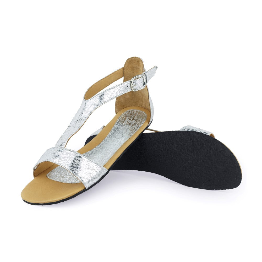 CLIQ Silver-Sandalen von ZAQQ mit silbernem Metallic-Finish, offenen Zehen, Knöchelriemen und einer Kautschuksohle auf weißem Hintergrund.