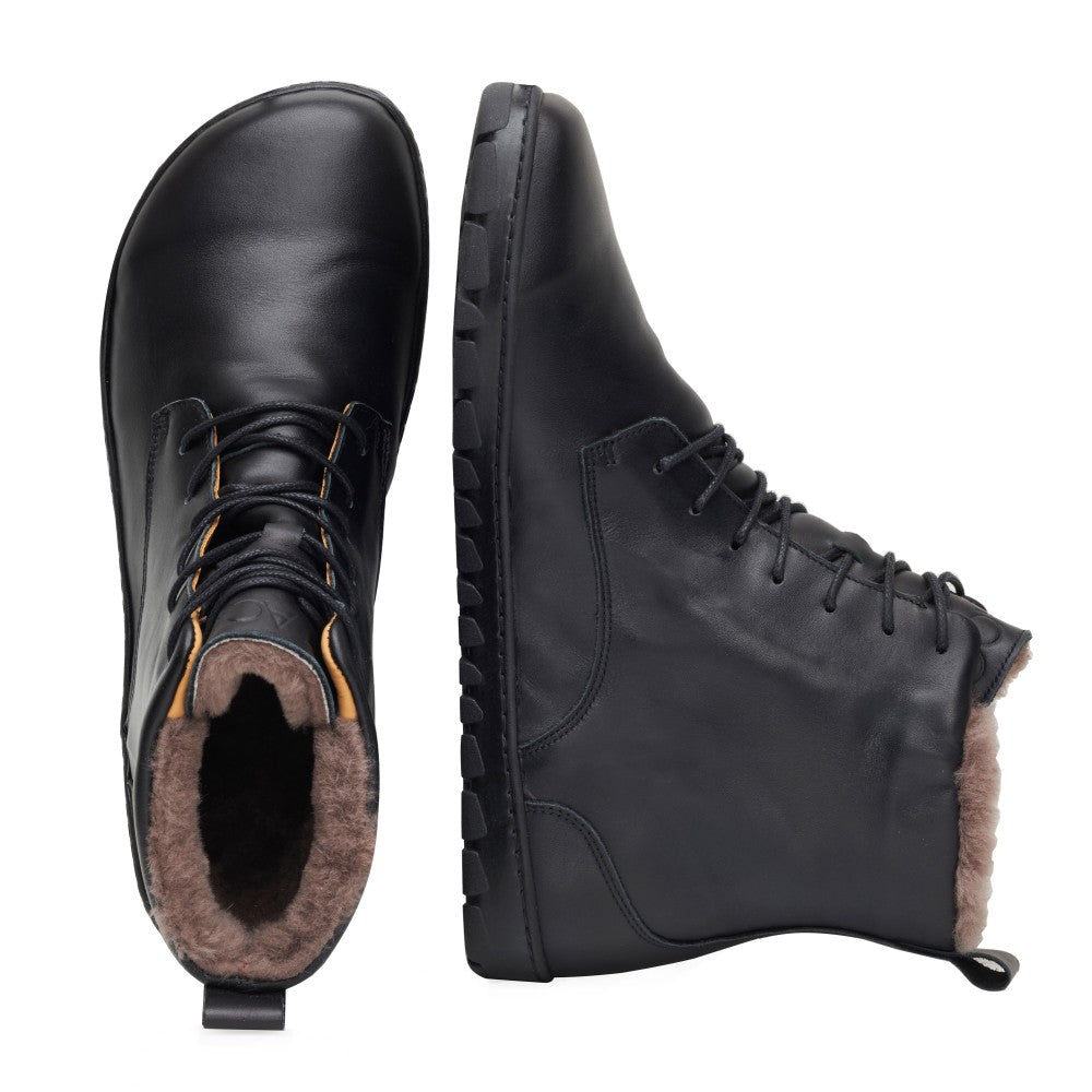 Ein Paar QUINTIC Winter Waterproof Black-Stiefel von ZAQQ wird vor einem weißen Hintergrund präsentiert. Ein Stiefel steht aufrecht und zeigt die Schnürung vorne und das gemütliche braune Innenfutter aus Lammfellfutter. Der andere Stiefel liegt auf der Seite und betont die strukturierte Sohle und die Seitennähte. Das Gesamtdesign ist schlicht und minimalistisch.