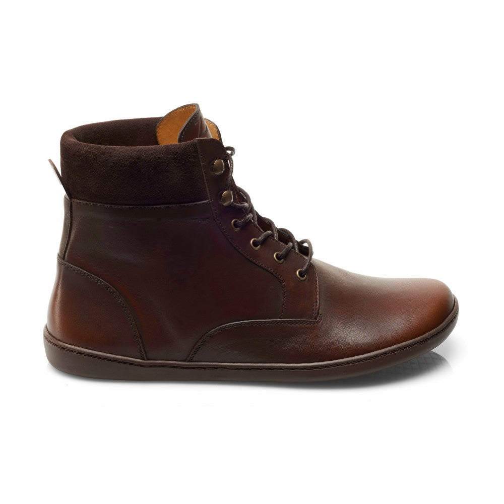 Der QORBY Brown von ZAQQ ist ein stilvoller brauner Lederstiefel mit dunklen Schnürsenkeln und einem gepolsterten Schaft aus Wildleder. Dieses geschmeidige, halbhohe Design besticht durch ein elegantes, glattes Finish und präsentiert sich in einem minimalistischen Seitenprofil vor einem weißen Hintergrund.