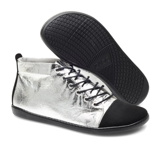 Wir präsentieren die stylischen ZAQQ QIVO Mid Pinatex High-Top-Sneaker mit metallischem Silber-Finish und schwarzen Akzenten. Diese veganen Sneaker haben schwarze Schnürsenkel, eine strukturierte schwarze Sohle für optimalen Komfort und ein geprägtes Logo auf der Unterseite und vereinen Mode perfekt mit umweltbewusstem Design.