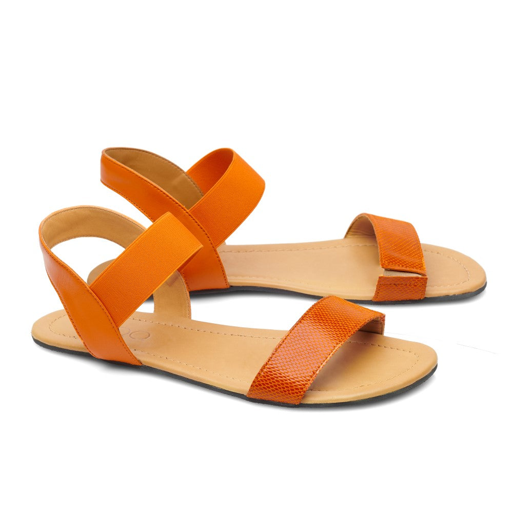 Diese ZAQQ SLIQ-Orange Sandalen sind eine schicke Barfußsandale mit zwei breiten Riemen, einer mit Struktur, der andere glatt. Mit einer flachen Sohle und offenem Absatz bieten sie lässige Eleganz.