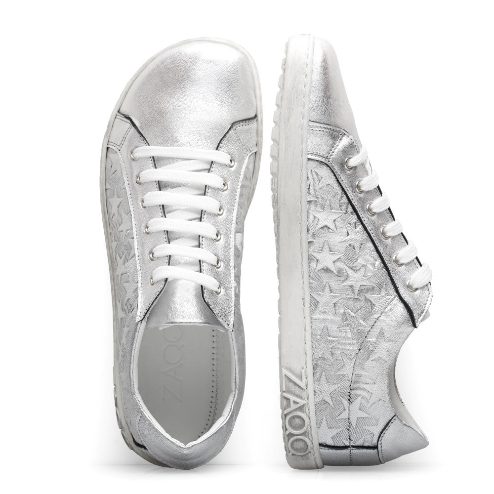 ZAQQ präsentiert die SLOQ Stars Silver Metallic-Sneaker mit auffälligem Sternenmuster an den Seiten und weißen Schnürsenkeln. Ihr schlankes Design in Kombination mit Gummisohlen bietet einen lässigen und dennoch trendigen Look und macht sie ideal für jeden modebewussten Sneaker-Liebhaber.